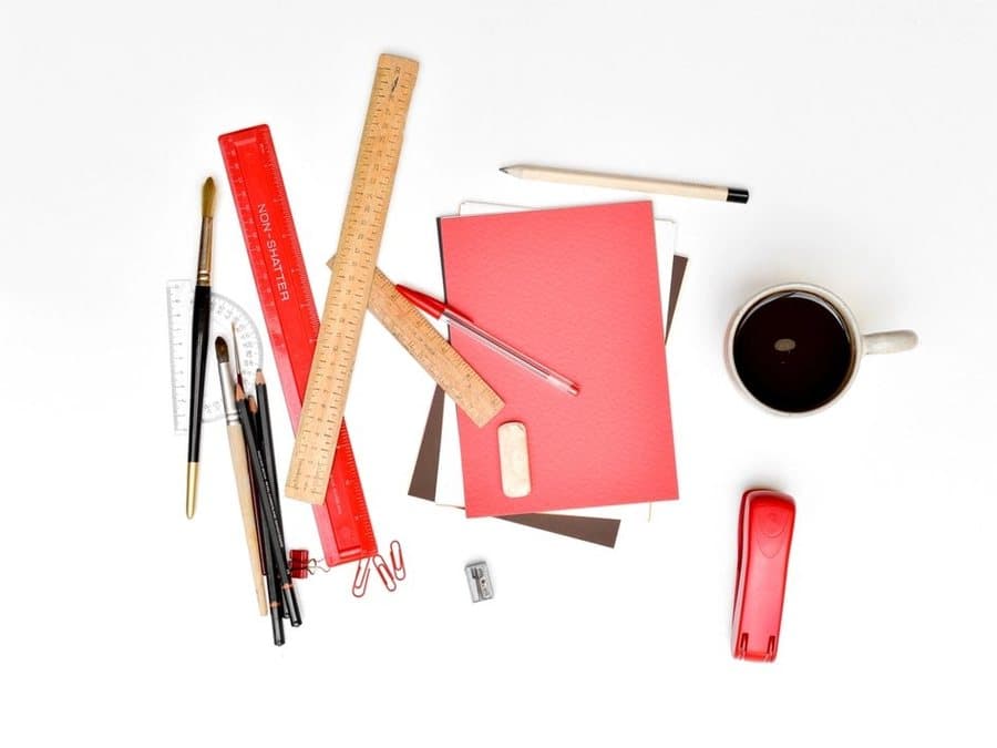 Rulers, pencils, a notebook and a stapler laid out on a desk