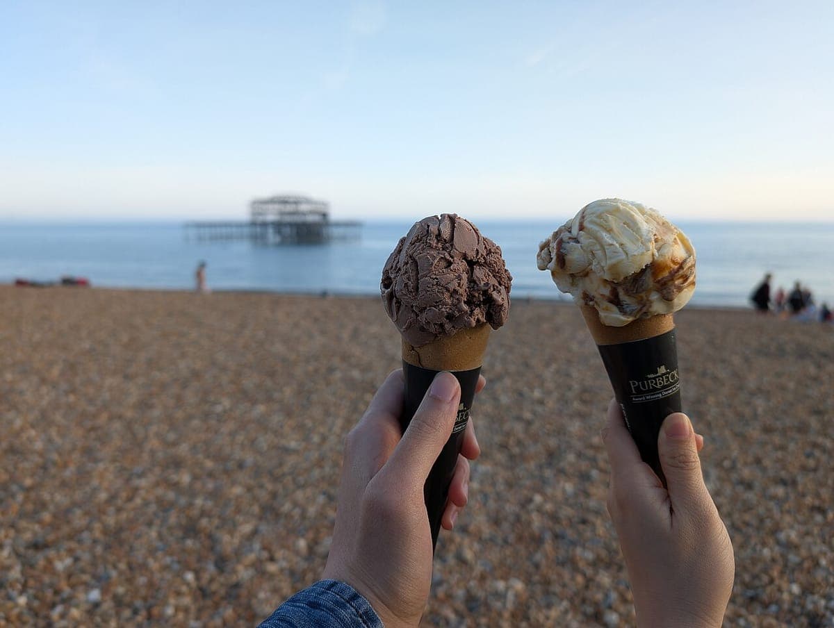 Two friends holding up ice cream cones together