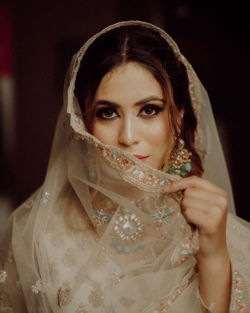 Bride looking over an embroidered veil