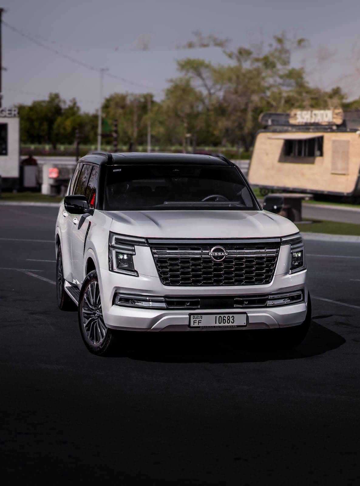White SUV with a black roof parked on dark tarmac