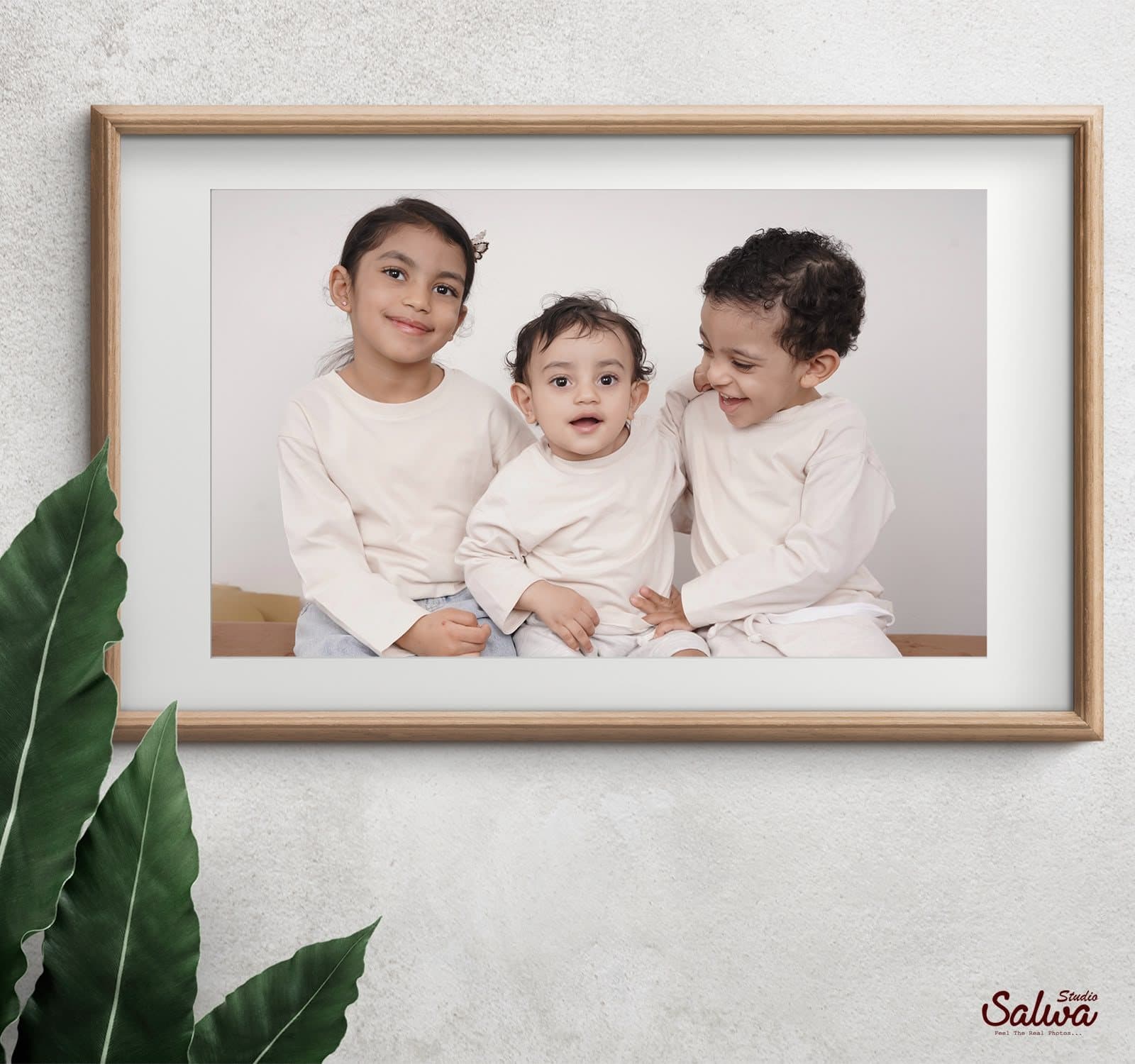 Framed portrait of three children on a wall