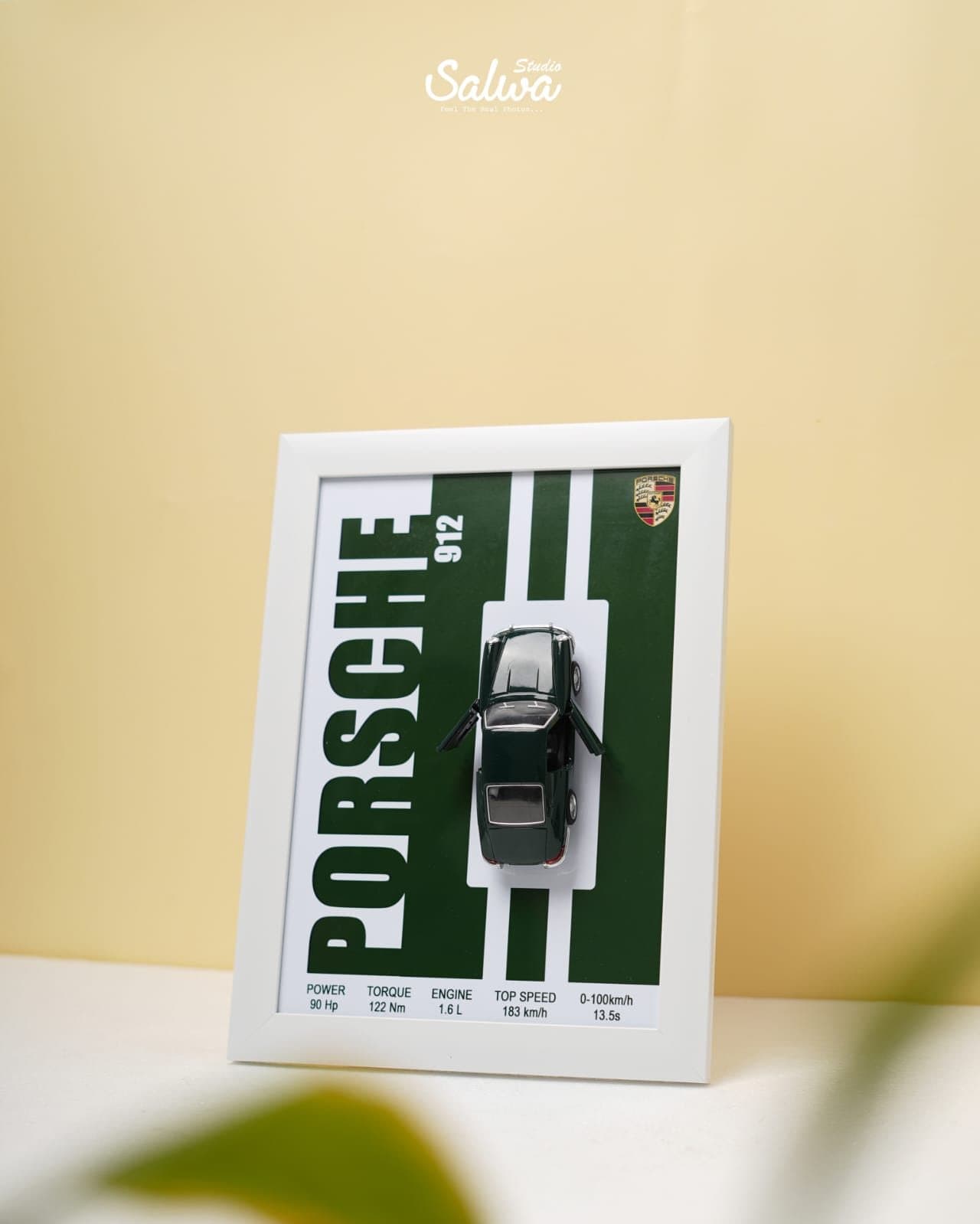 Framed car poster with a model car mounted on it